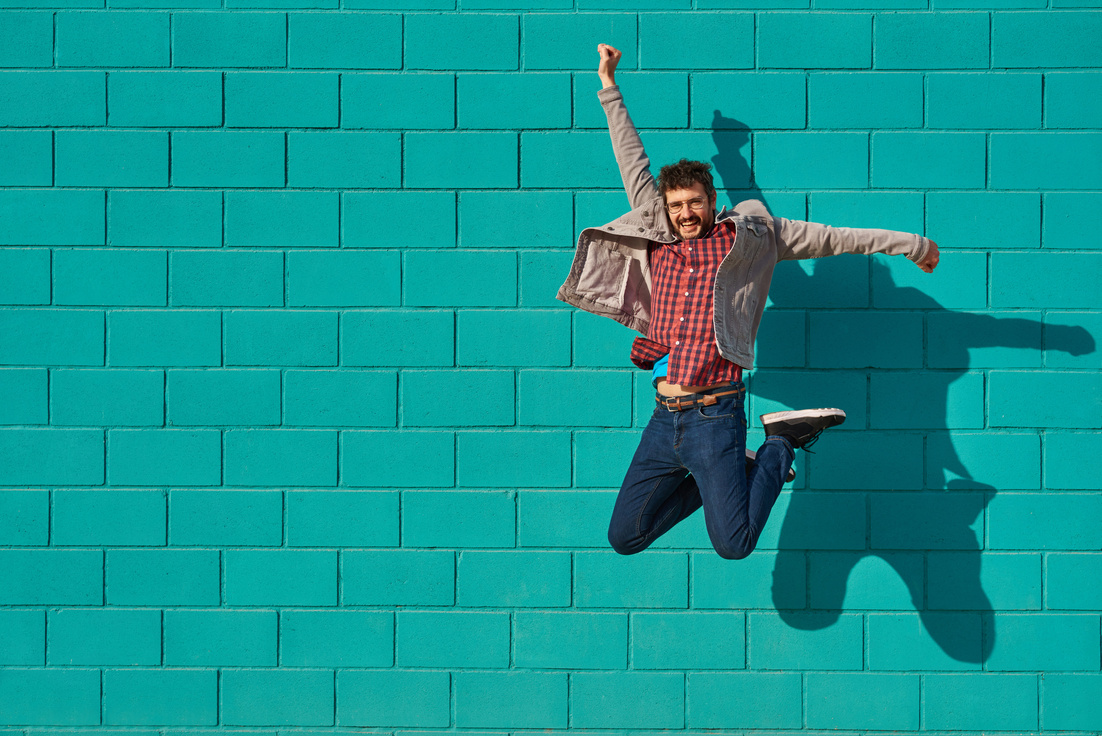  Happy Man Jumping against a Blue Bright Wall 